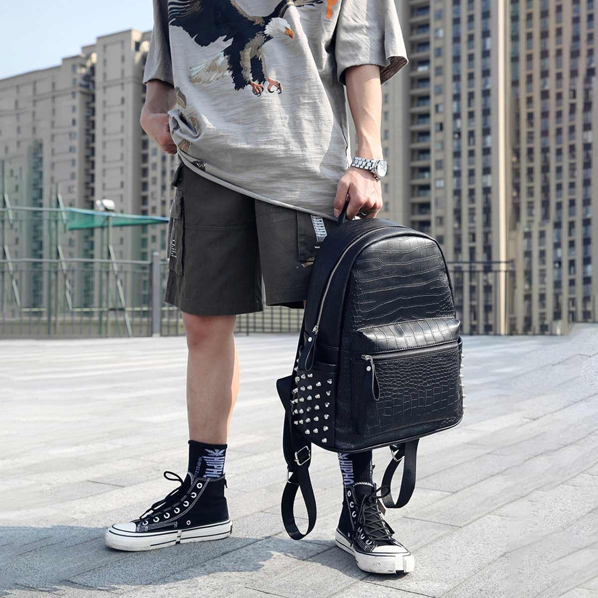 Black alligator pattern backpack with spikes in urban setting