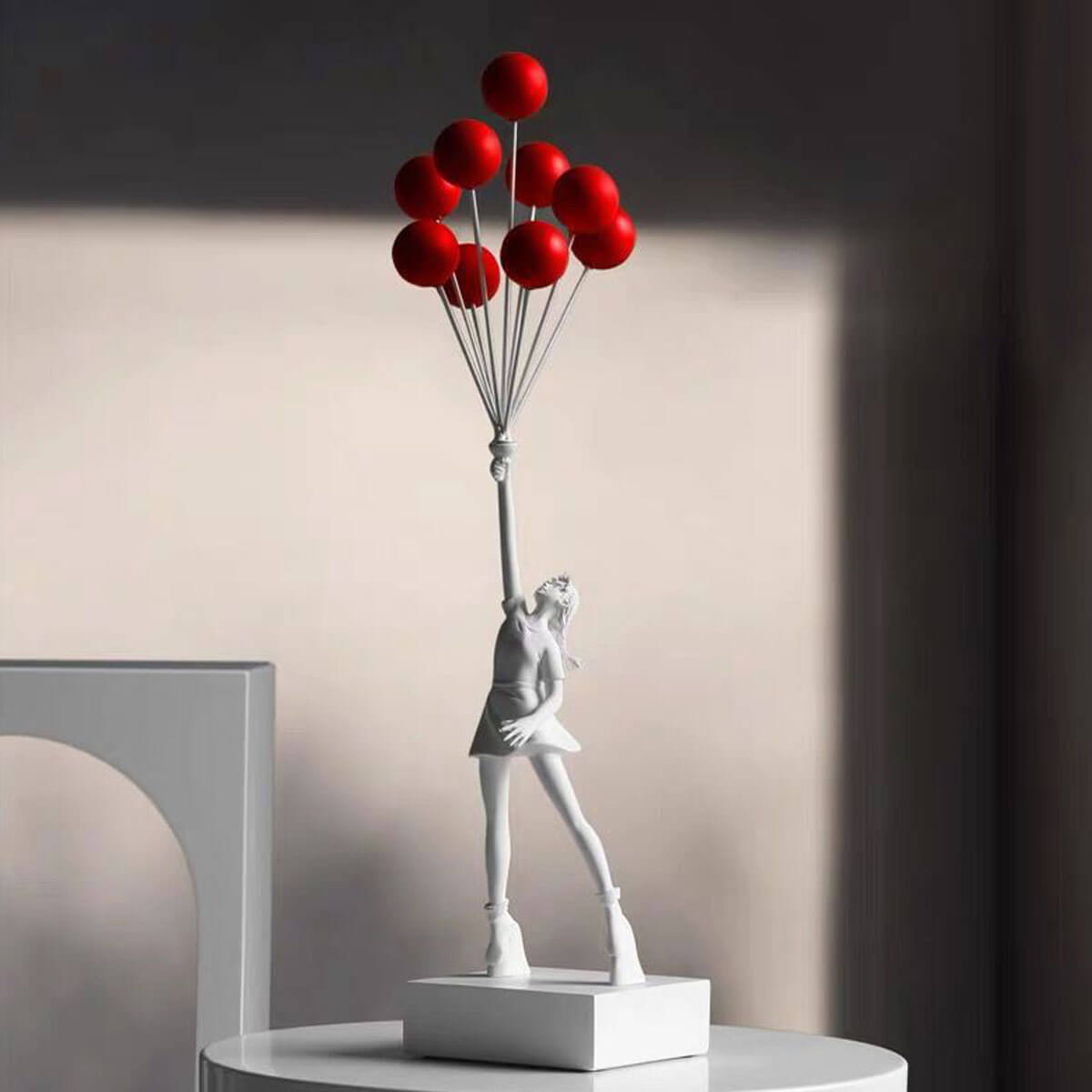 White Flying Balloon Girl Banksy Statue with red balloons, minimalist art sculpture with dramatic lighting