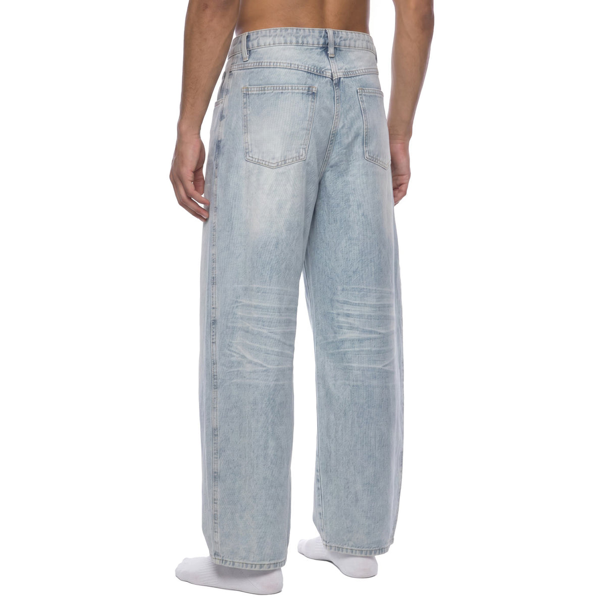 Back angle view of faded light blue baggy jeans showing rear pockets and knee whiskering