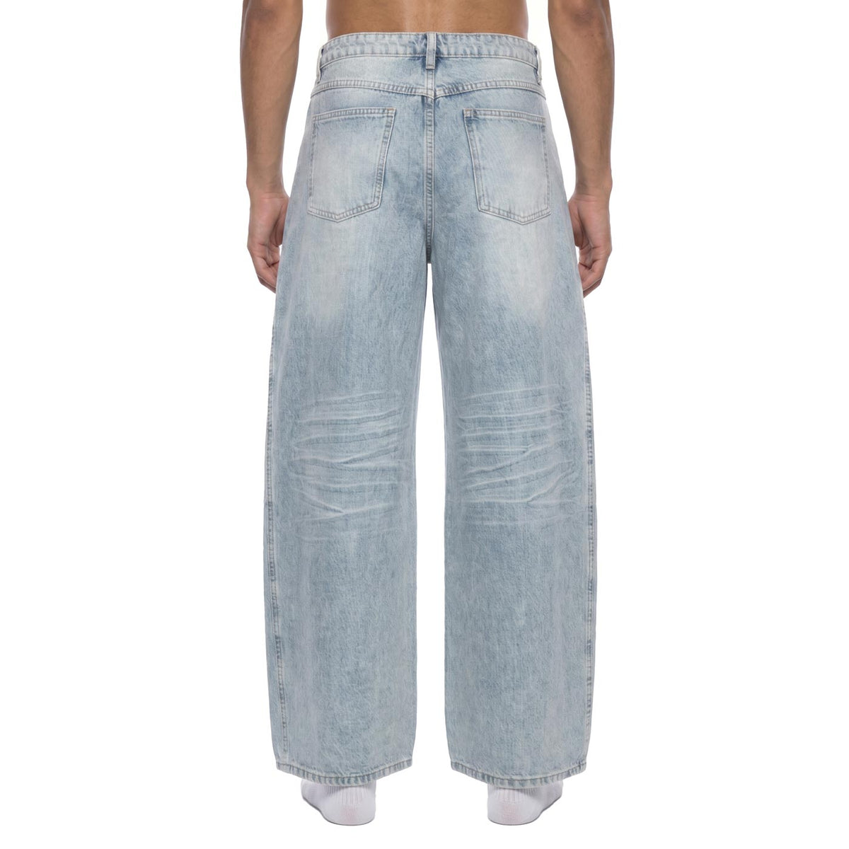 Back view of light blue wide leg denim pants on model showing back patch pockets and vintage wash