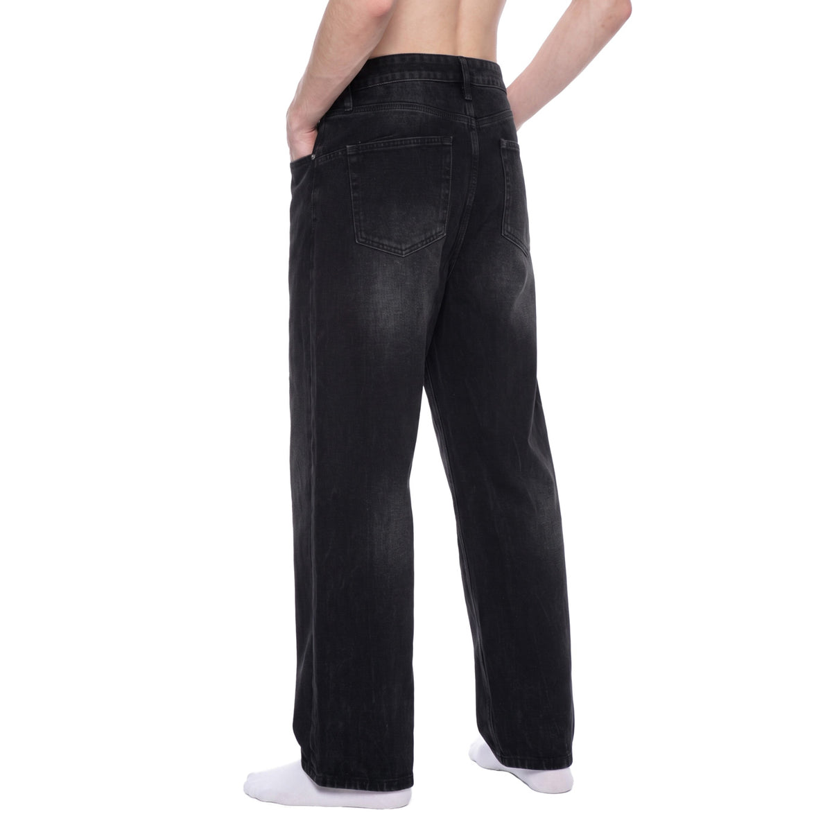 Back angle view of washed black baggy jeans showing rear pockets and vintage sunfade